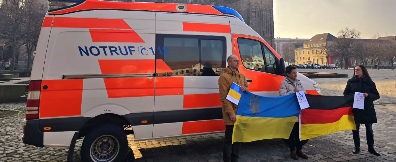 Menschen stehen wor einem Rettungswagen