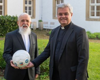 Paderborns Erzbischof Dr. Udo Markus Bentz (r.) und Magdeburgs Bischof Dr. Gerhard Feige (l.), halten einen Fußball