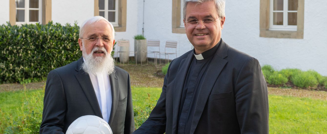 Paderborns Erzbischof Dr. Udo Markus Bentz (r.) und Magdeburgs Bischof Dr. Gerhard Feige (l.), halten einen Fußball