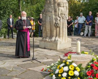 Ein Priester steht an einem Mikrofon