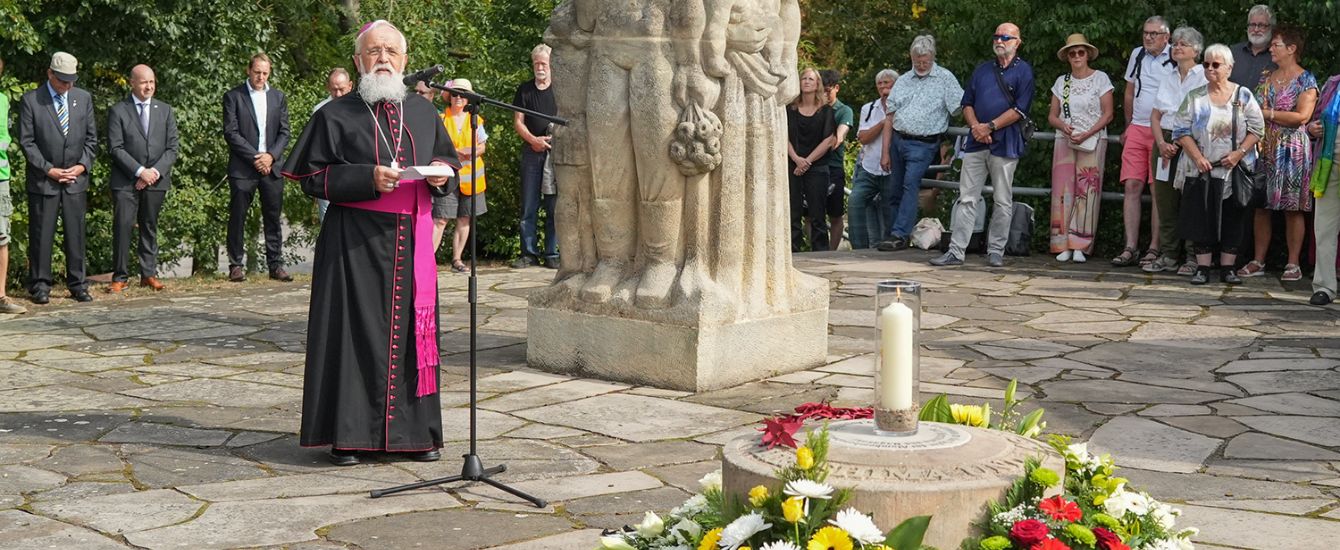 Ein Priester steht an einem Mikrofon