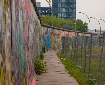 Berliner Mauer mit Zaun daneben