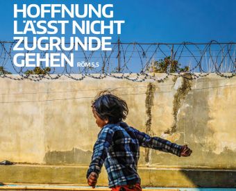 Weiße Schrift, die vor einem Stacheldrahtzaun sagt: Hoffnung lässt nicht zugrunde gehen