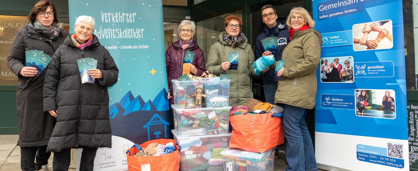 Menschen stehen mit Kisten vor einem Laden