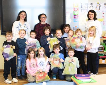 Schülerinnen und Schüler im Klassenzimmer zeigen ihre Martinstüten