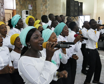 Ein nigerianischer gemischter Chor wird beim Singen von einer Band begleitet. Das Foto wurde für den Weltgebetstag 2026 von Albrecht Ebertshäuser zur Verfügung gestellt.
