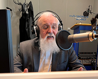 Ein Mann vor einem Mikrofon mit Kopfhörern