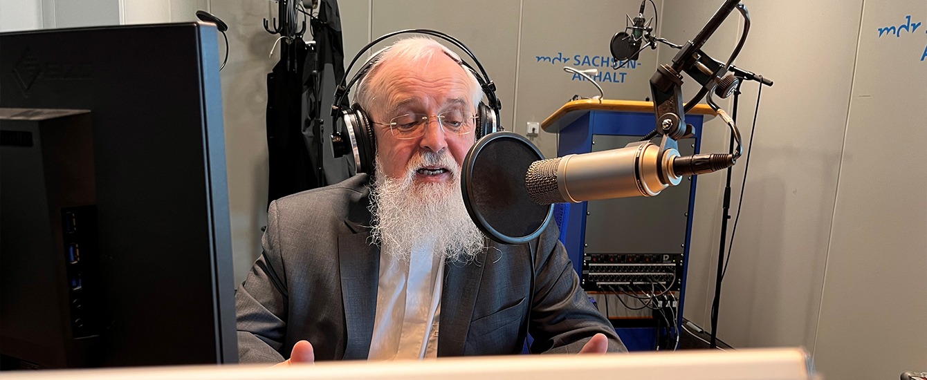 Ein Mann vor einem Mikrofon mit Kopfhörern