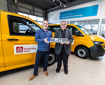 Zwei Männer stehen vor einem gelben Auto