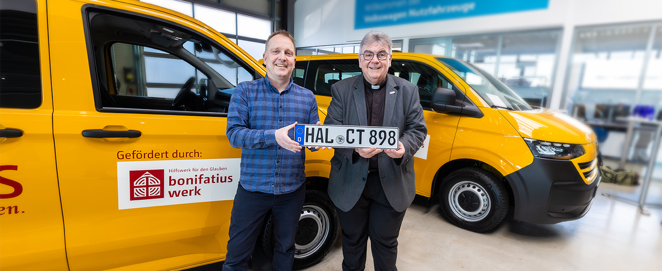 Zwei Männer stehen vor einem gelben Auto