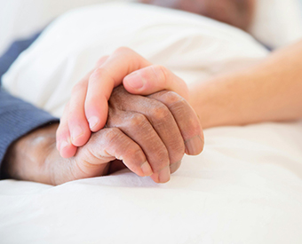 Eine Hand liegt schützend über einer anderen