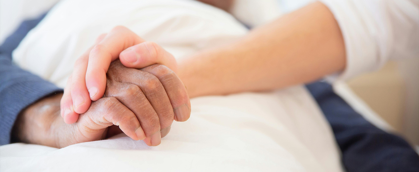 Eine Hand liegt schützend über einer anderen