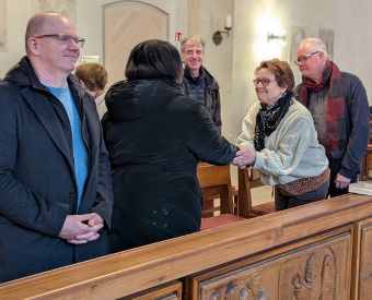 Menschen im Gottesdienst reichen sich die Hände