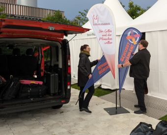 Zwei Menschen laden ein Auto aus