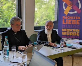Bischof Feige und Erzbischof Bentz sitzen an einem Tisch