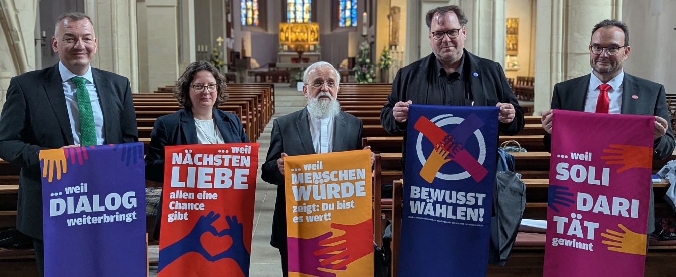 Menschen mit dem Bischof und Bannern in einer Kirche