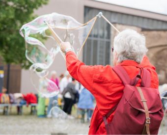 Eine Frau lässt eine Riesenseifenblase entstehen