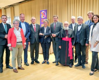 Ministerpräsident Sven Schulze mit Ministern und den Bischöfen in enem Saal
