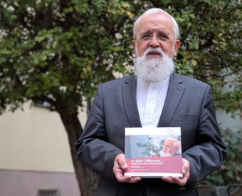 Bischof Feige mit Buch in der Hand