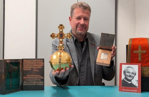 Ein Mann hält historische Gegenstände in den Händen
