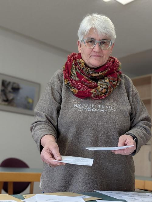 Eine Frau hält Zettel in einer Hand