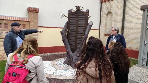 Menschen betrachten die Skulptur an der halleschen Synagoge.