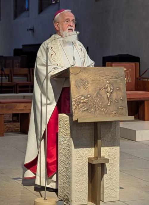 Ein Priester steht am Ambo