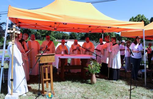 Priester unter einem Sonnendach beim Gottesdienst