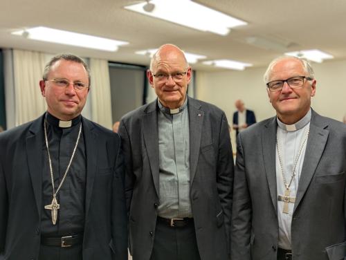 Drei Priester schauen in die Kamera