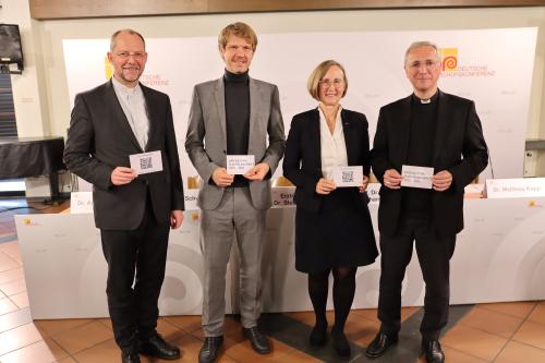 Vier Menschen lächeln in die Kamera