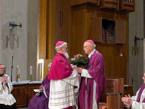 Ein Mann überreicht einem anderen einen Blumenstrauß