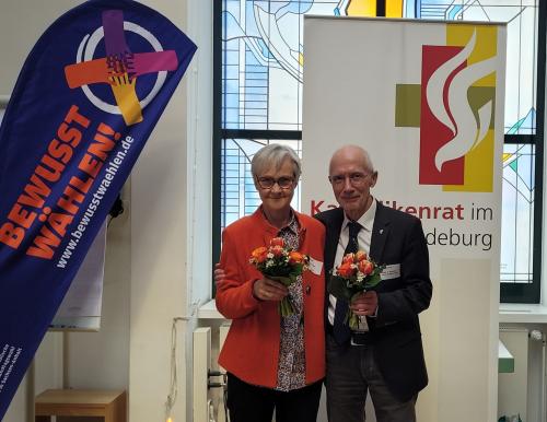 Zwei Menschen vor einem Plakat