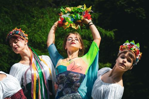 Drei junge Frauen in bunten Kostümen tanzen