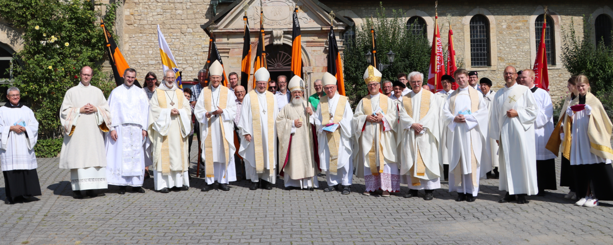 Bischöfe stehen vor einer Kirche