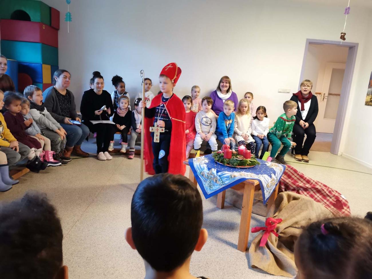 Bischof mit Kindern in einem Raum