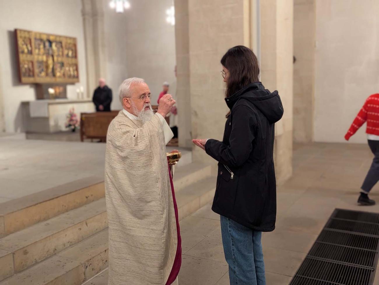Ein Priester verteilt das Abendmahl