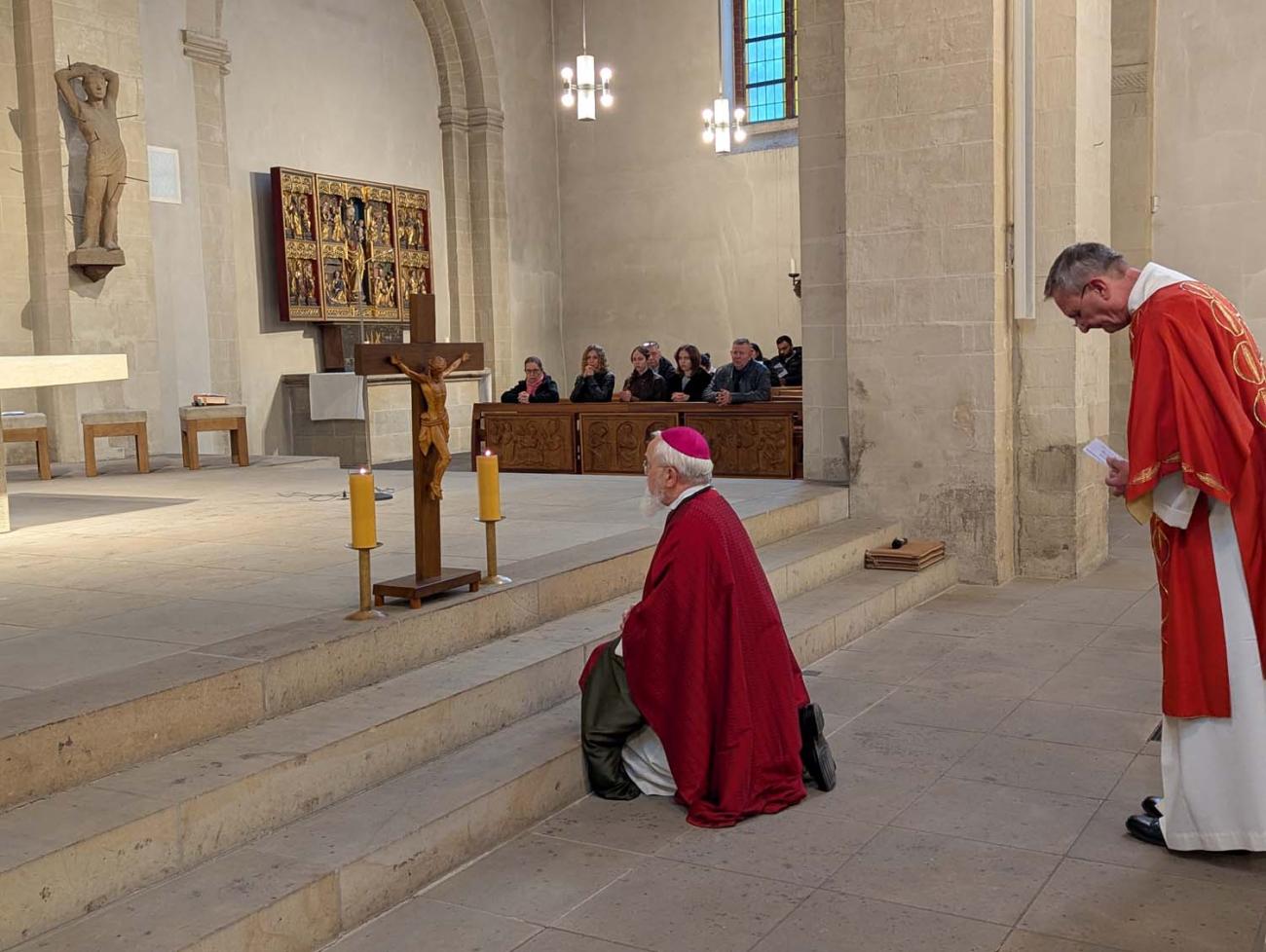 Der Bischof verneigt sich vor dem Kreuz