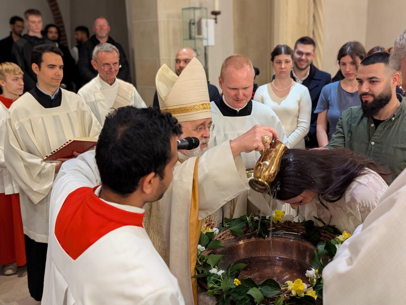 Ein Priester tauft eine Frau