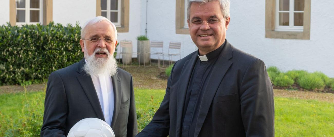 Paderborns Erzbischof Dr. Udo Markus Bentz (r.) und Magdeburgs Bischof Dr. Gerhard Feige (l.), halten einen Fußball