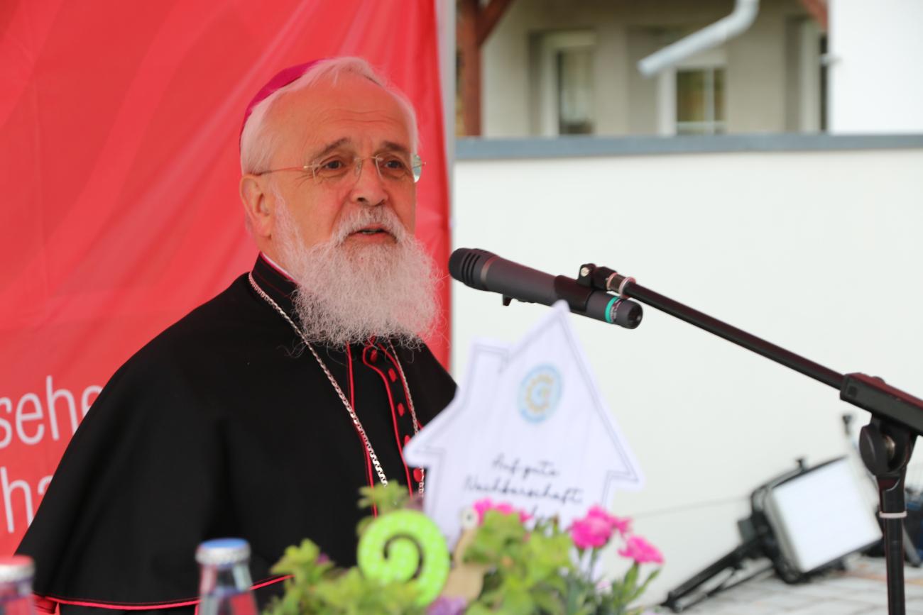 EIn Priester spricht an einem Mikrofon