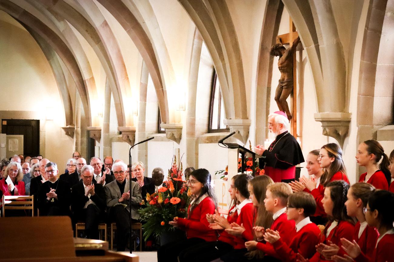 Bischof Feige am Rednerpult mit Publikum