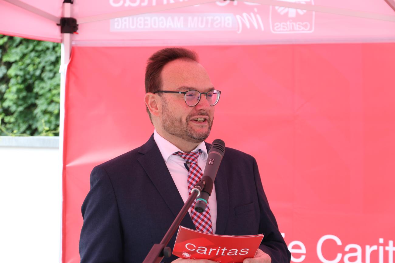 EIn Mann spricht an einem Mikrofon