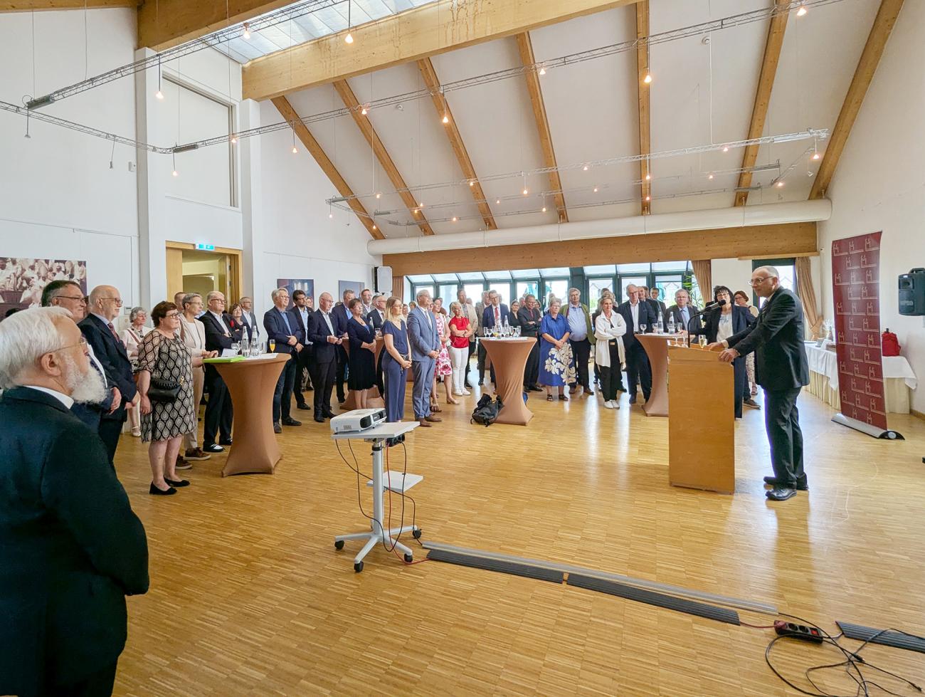 Empfang im Roncalli-Haus, Menschen hören einer Rede zu