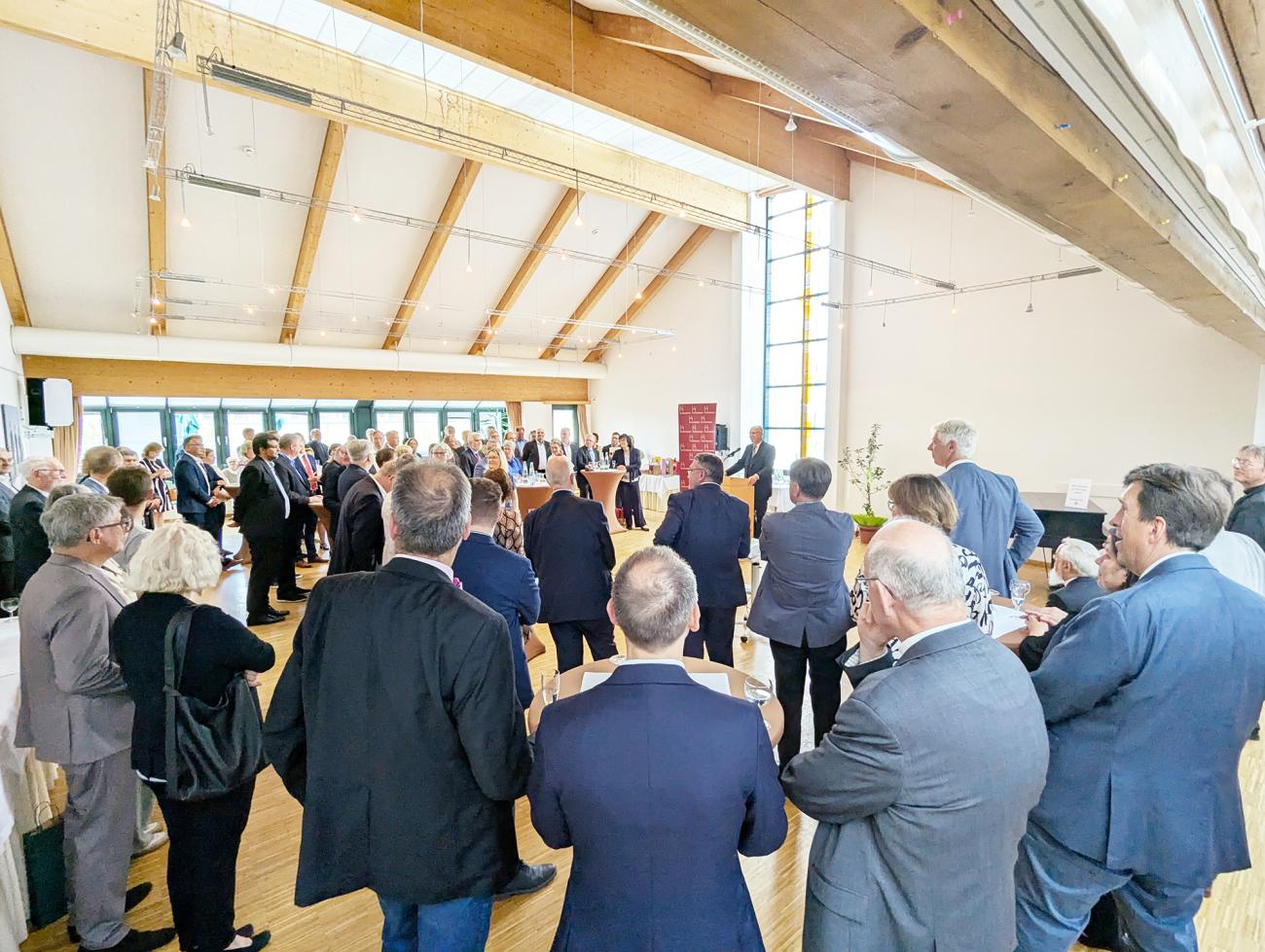 Empfang im Roncalli-Haus, Menschen hören einer Rede zu