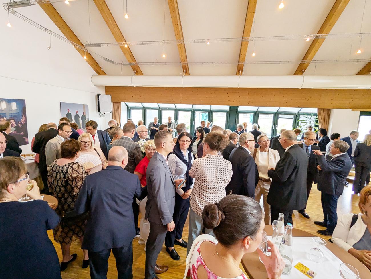 Empfang im Roncalli-Haus, Menschen hören einer Rede zu