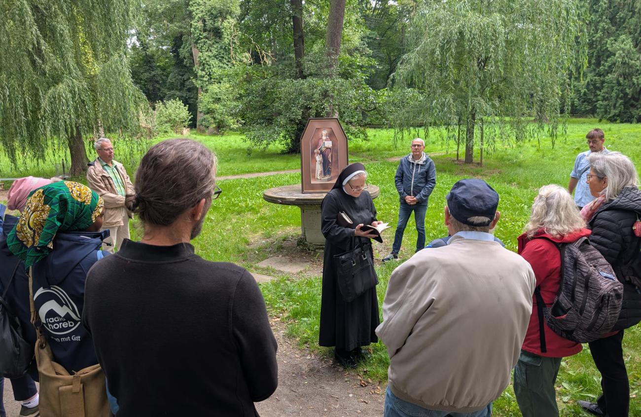 Andacht im Park, Menschen hören einer Nonne zu