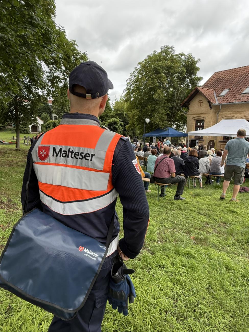 Ein Malteser-Mitarbeiter beobachtet das Treiben auf dem Fest