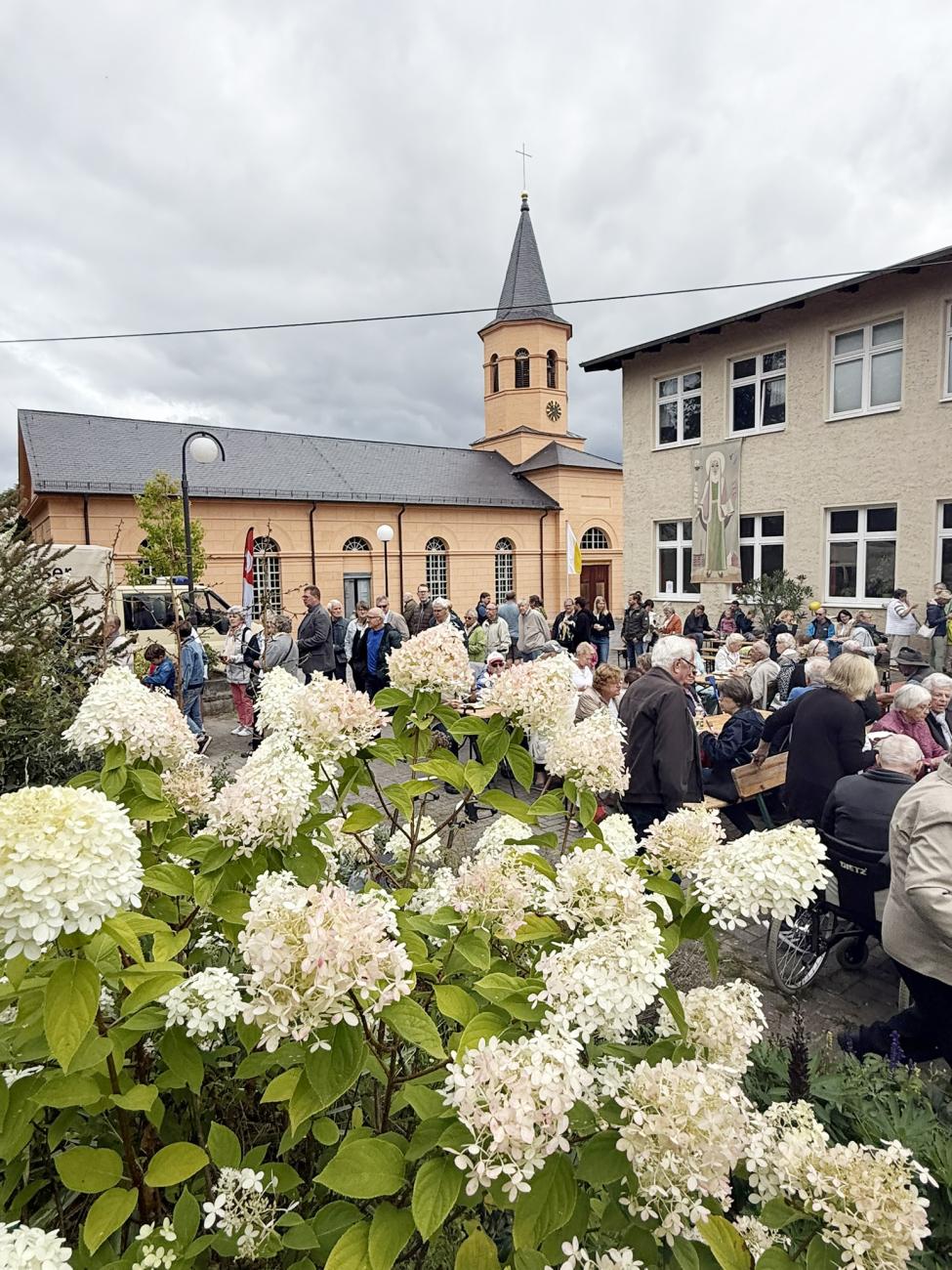 Gläubige sitzen auf Bänken, Essen gemeinsam und tauschen sich aus
