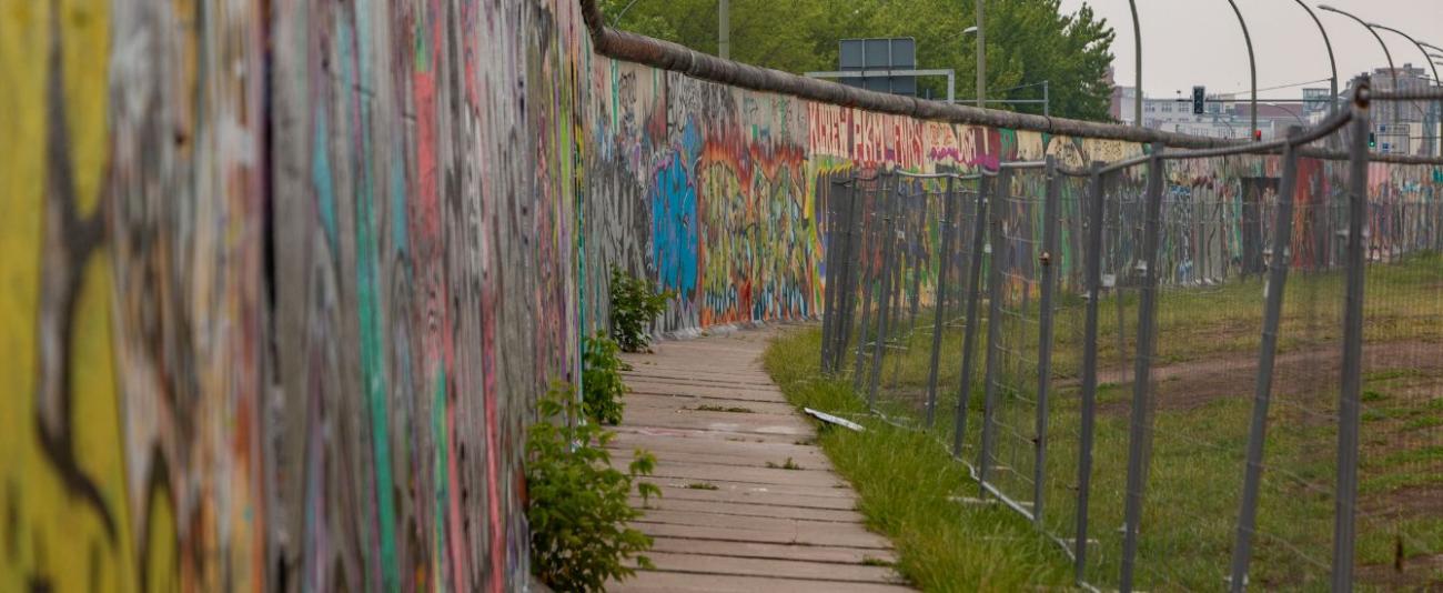 Berliner Mauer mit Zaun daneben