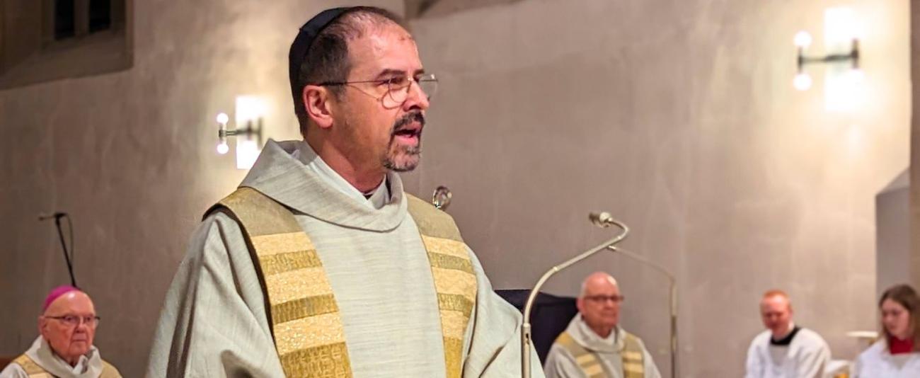 Ein Priester steht am Ambo